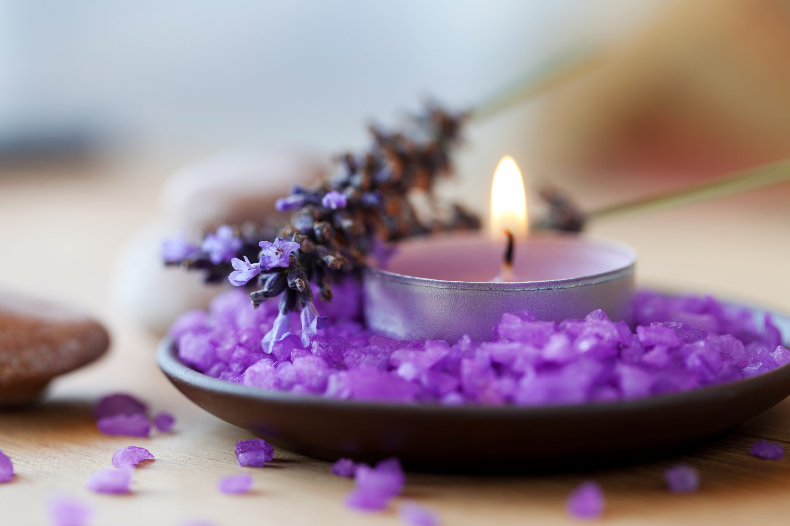 Candle in a saucer with salt baths and sprigs of lavender